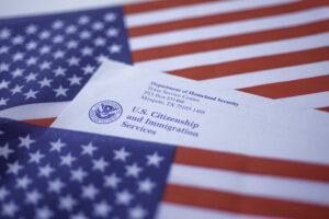 Letter (Envelope) from USCIS covered in flag of USA on American colors background.